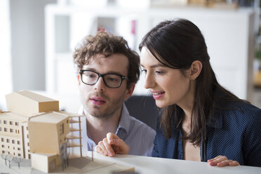 Mann und Frau diskutieren über ein Architekturmodell im Büro - FKF02317