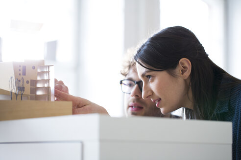 Mann und Frau diskutieren über ein Architekturmodell im Büro - FKF02318