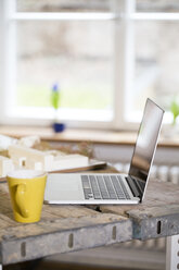 Laptop und Kaffeetasse in einem modernen informellen Büro - FKF02319