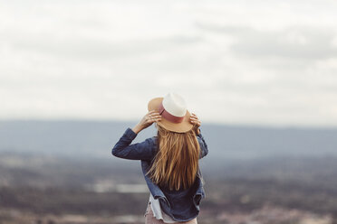 Back view of redheaded woman wearing hat looking at distance - JPF00204