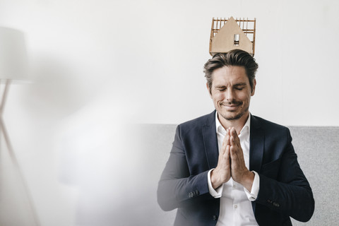 Man balancing an architectural model on his head stock photo