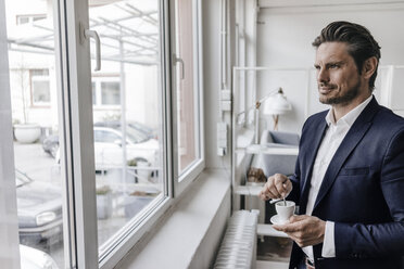 Geschäftsmann trinkt einen Kaffee am Fenster - KNSF01303