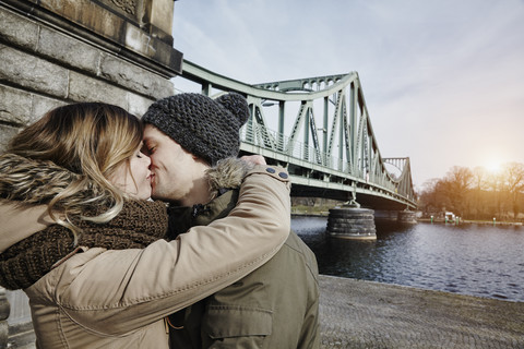 Deutschland, Potsdam, junges Paar küsst sich an der Glienicker Brücke, lizenzfreies Stockfoto