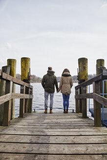 Germany, Potsdam, rear view of young couple standing on jetty at Havel River - ANHF00035