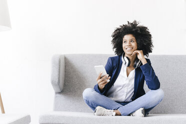 Young businesswoman using smartphone with headset - KNSF01349