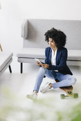 Young businesswoman using smartphone with headset - KNSF01352