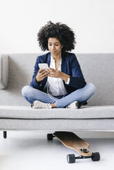 Young businesswoman using smartphone with headset - KNSF01390