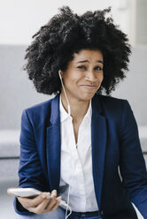 Young businesswoman using smartphone with headset - KNSF01391