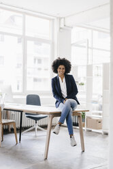 junge Geschäftsfrau in ihrem Büro sitzend - KNSF01395