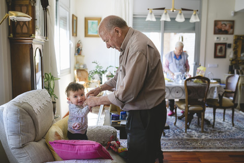 Urgroßvater kümmert sich um ein kleines Mädchen zu Hause, lizenzfreies Stockfoto