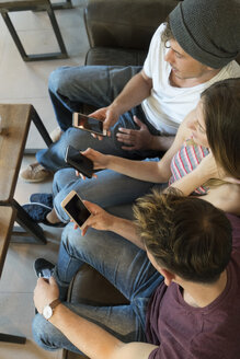 Three friends using their cell phones in a cafe - KKAF00819