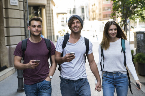 Freunde mit Handys beim Spaziergang in der Stadt - KKAF00832