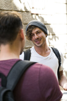 Two young men talking in the city - KKAF00833