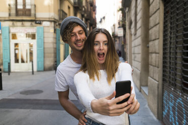 Glückliches junges Paar macht ein Selfie in der Stadt - KKAF00840