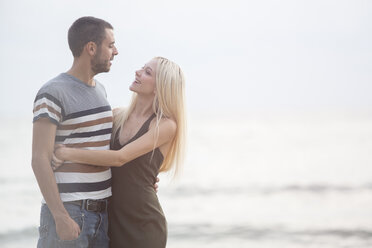 Happy couple embracing by the sea - ZOCF00385