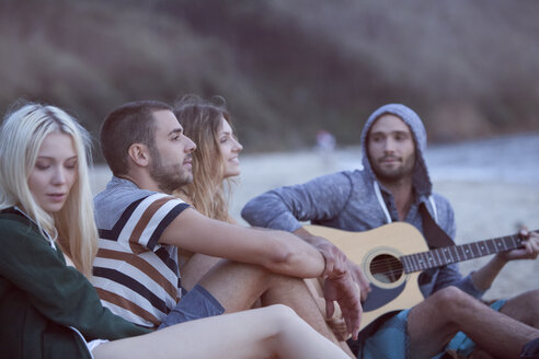 Vier Freunde am Strand beim Musizieren - ZOCF00408