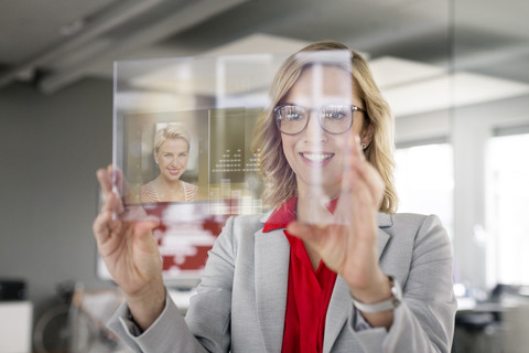 Businesswoman communicating via futuristic portable device stock photo