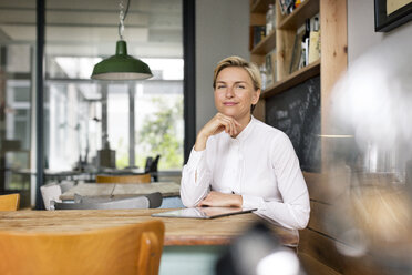 Portrait of confident blond woman sitting at table - PESF00598