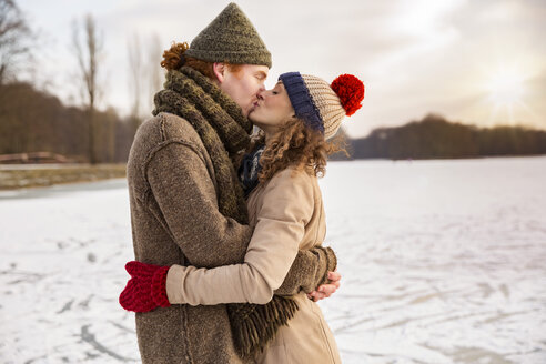 Couple kissing on frozen lake - MFF03539