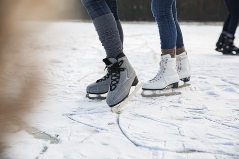 Feet of ice skating people on frozen lake stock photo