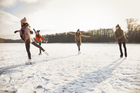Glückliche Freunde beim Schlittschuhlaufen auf einem zugefrorenen See - MFF03547