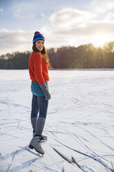 Porträt einer Frau beim Schlittschuhlaufen auf einem zugefrorenen See - MFF03556