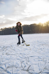 Mann spielt Eishockey auf gefrorenem See - MFF03566