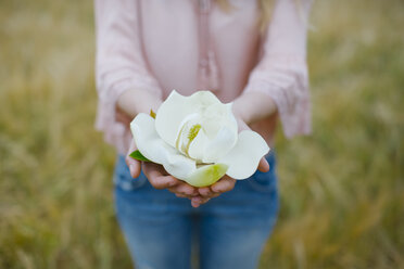 Woman showing Magnolia blossom, partial view - JPF00210