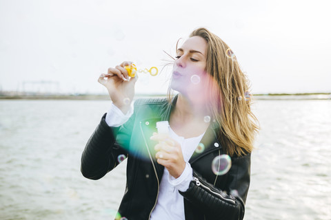 Young woman blowing soap bubbles stock photo