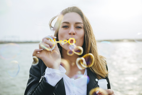 Young woman blowing soap bubbles stock photo