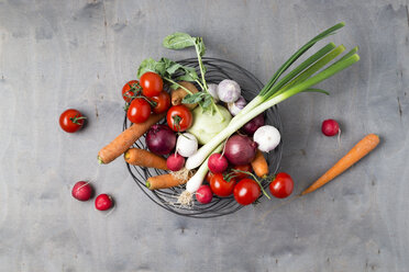 Wire basket with different vegetables on wood - MYF01922