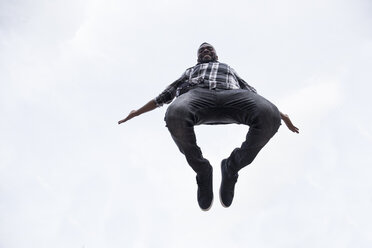 Happy young man jumping in the air - ABZF02034