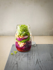 Preserving jar of raw food with fried salmon, chili sauce and peanuts - KSWF01807