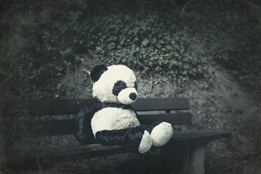 Panda-Plüschtier auf einer Bank - DWIF00855
