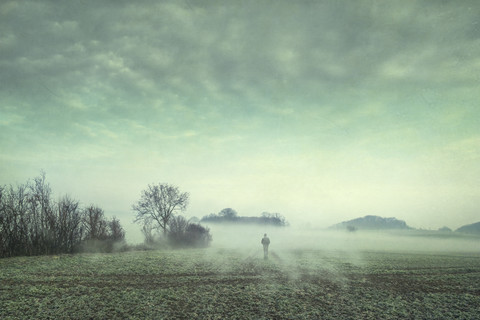 Mann auf Feld im Nebel, Komposit, lizenzfreies Stockfoto