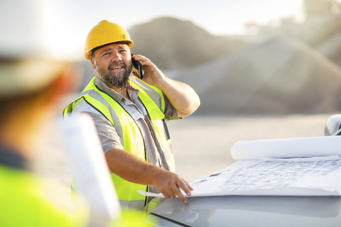 Quarry worker on site talking on the phone stock photo