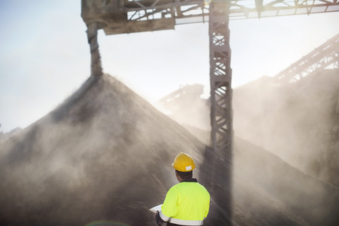 Worker wearing protective clothing standing at quarry stock photo