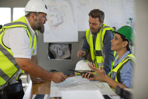 Workers discussing at site office stock photo