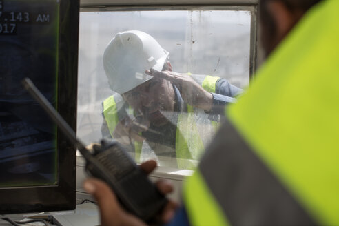 Workers at quarry, one holding radio device - ZEF13758