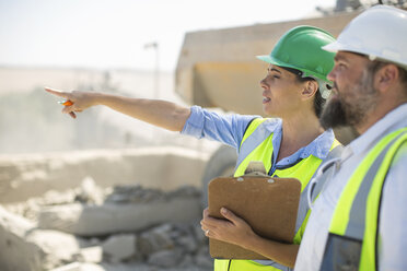 Male and female quarry workers discussing on site - ZEF13760