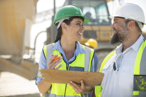 Male and female quarry workers discussing on site stock photo