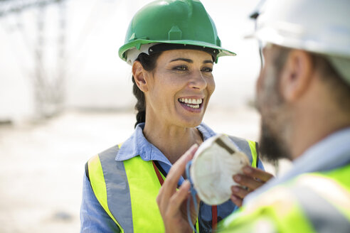 Male and female quarry workers discussing on site - ZEF13763