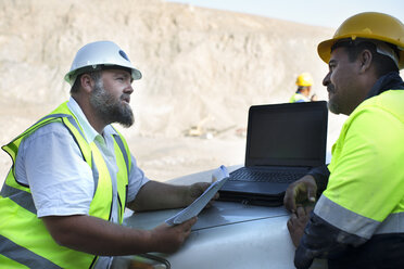 Workers at quarry discussing, leaning on car bonnet - ZEF13783