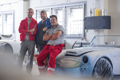 Automechaniker gemeinsam in der Werkstatt für Fahrzeugrestaurierung, lizenzfreies Stockfoto