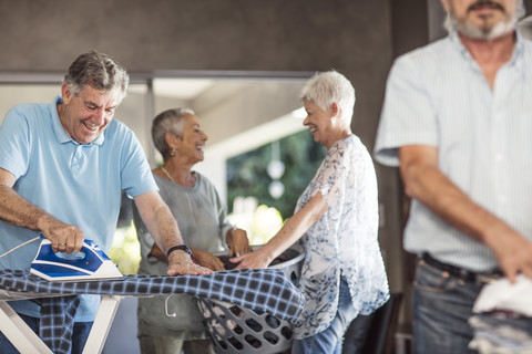 Seniors ironing clothes together stock photo