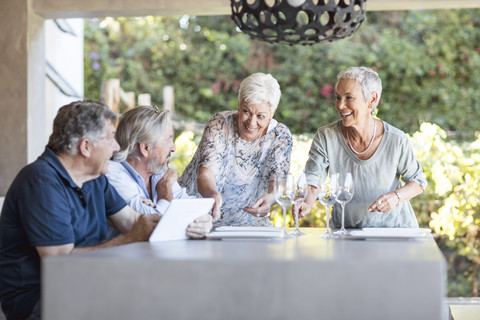 Two relaxed senior couples on terrace stock photo