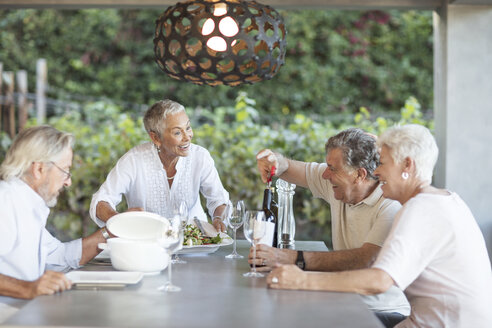 Lächelnde Seniorin serviert Mittagessen auf der Terrasse - ZEF13841