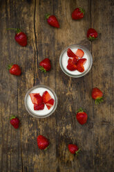 Zwei Gläser griechischer Joghurt mit Erdbeeren auf Holz - LVF06137