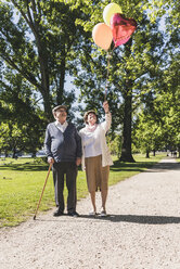 Älteres Paar mit Luftballons in einem Park - UUF10647