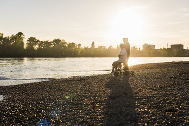 Seniorenpaar mit Rollator am Strand bei Sonnenuntergang - UUF10679